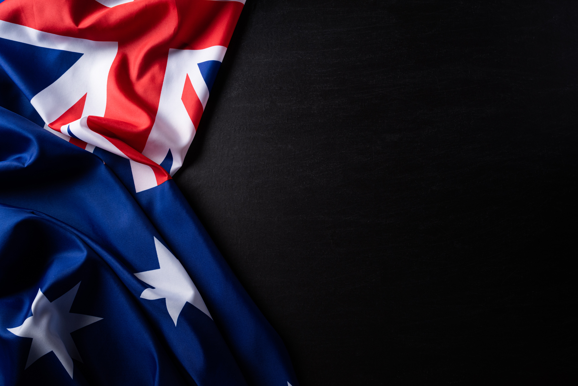 Australia day concept. Australian flag with the text Happy Australia day against a blackboard background. 26 January.